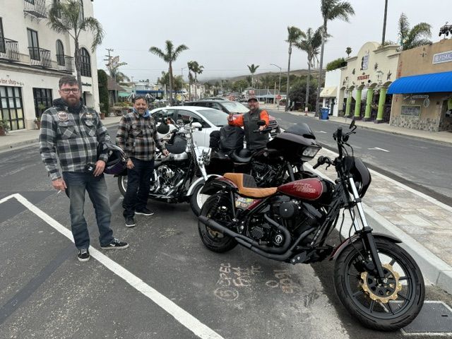 Riders and motorcycles parked on a coastal Highway 1 town street